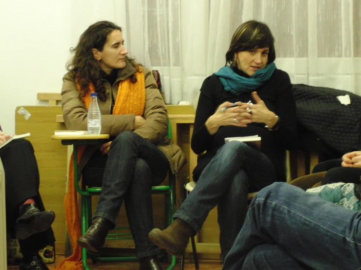 two women sitting on chairs in front of a door