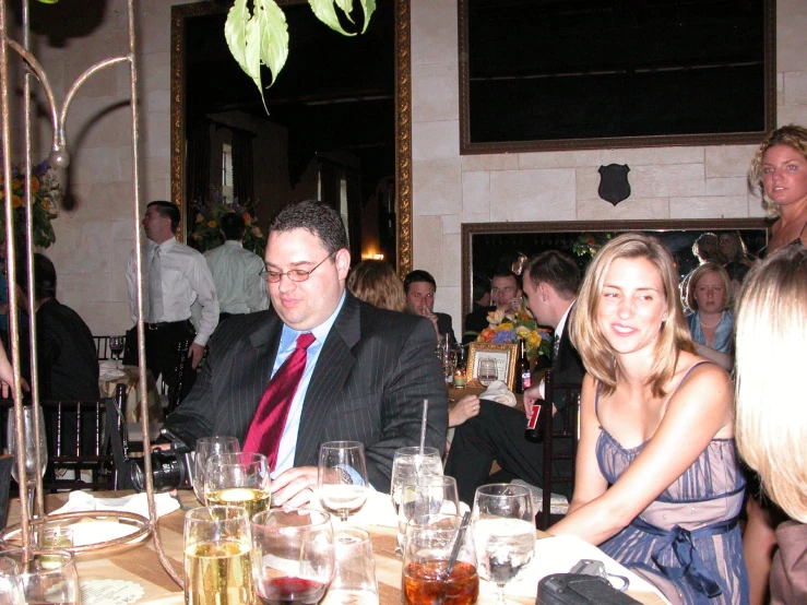 a man in a suit sitting at a table with two other people