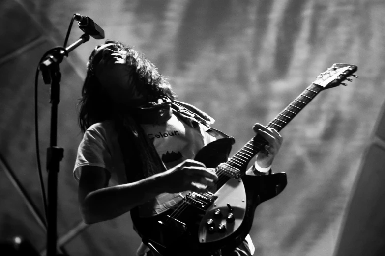 a man holding a guitar while standing on a stage