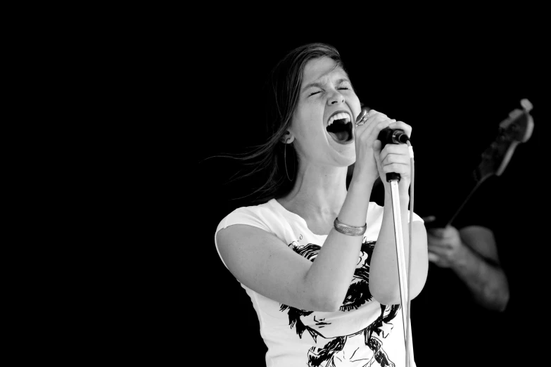 woman singing into microphone in black and white po