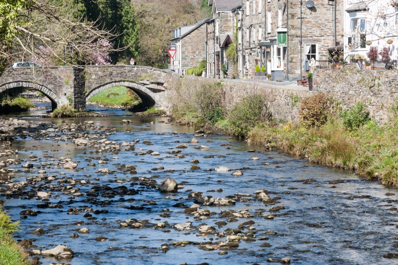 a stone bridge is over the water with stones on it