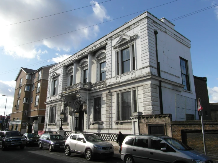 several cars parked on the side of a street next to buildings