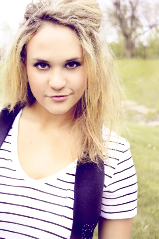 a young blonde girl wearing a black carrier