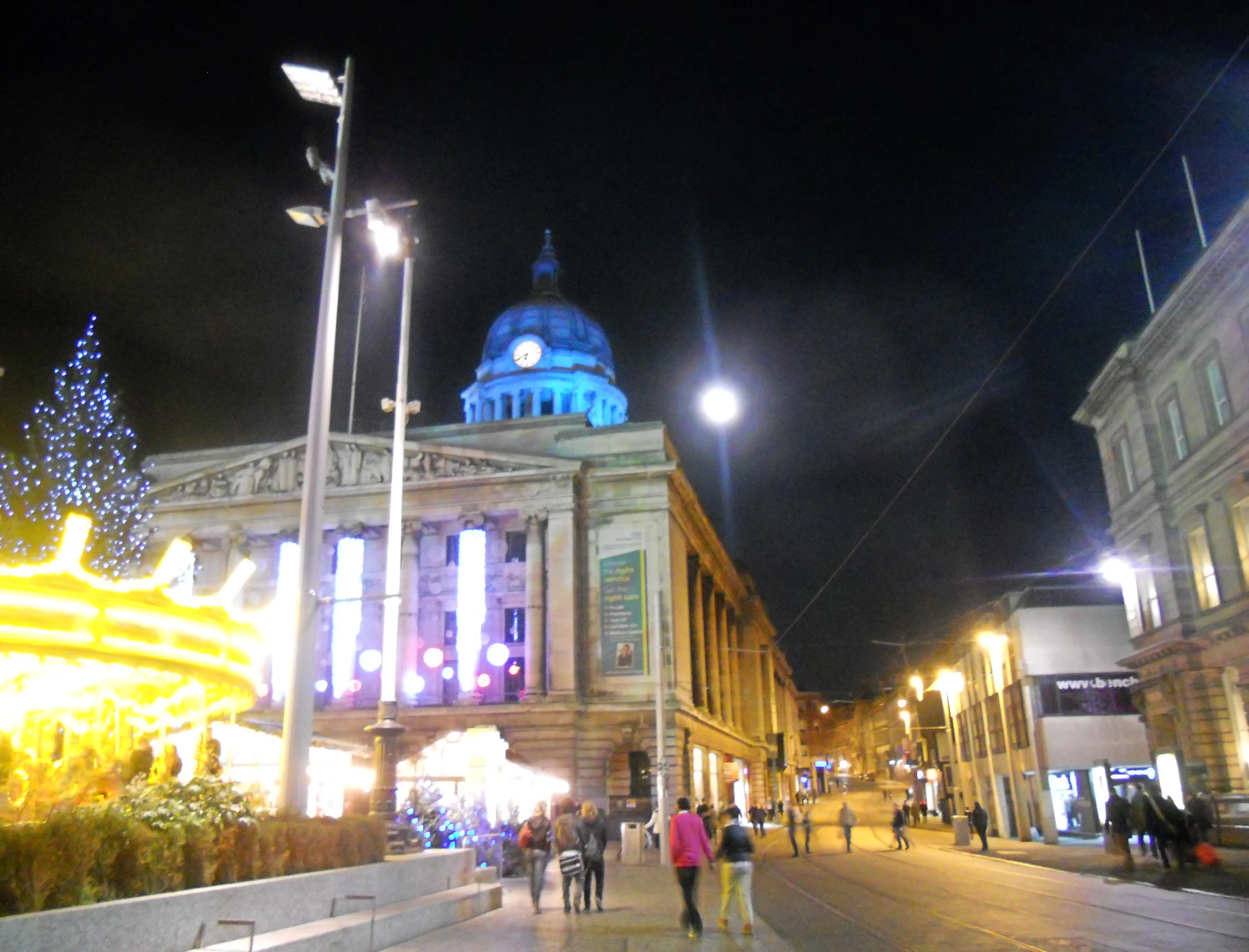 a large christmas tree with lights is displayed on the street