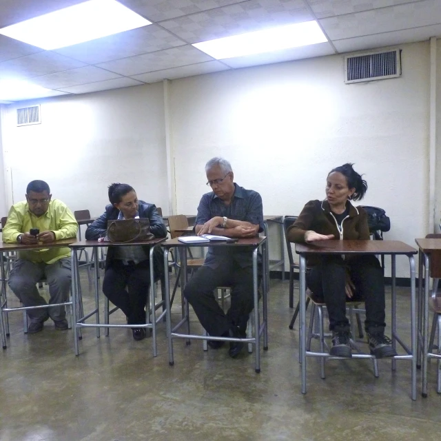 five people sitting at tables in a room