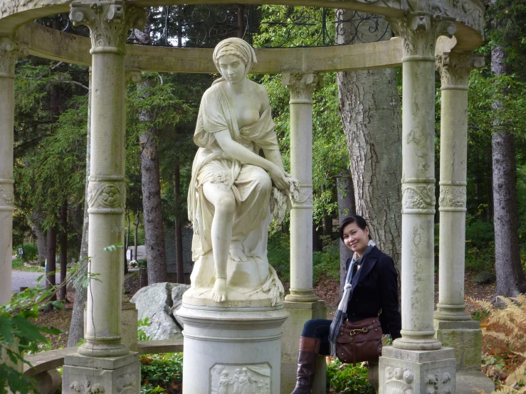 a woman standing next to a white statue