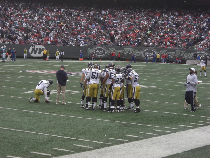 a team is huddling together during the football game