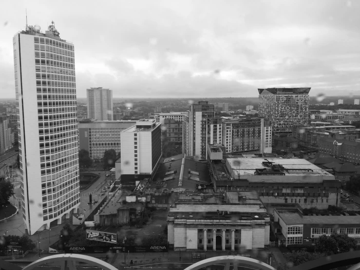 a large city in black and white with a cloudy sky