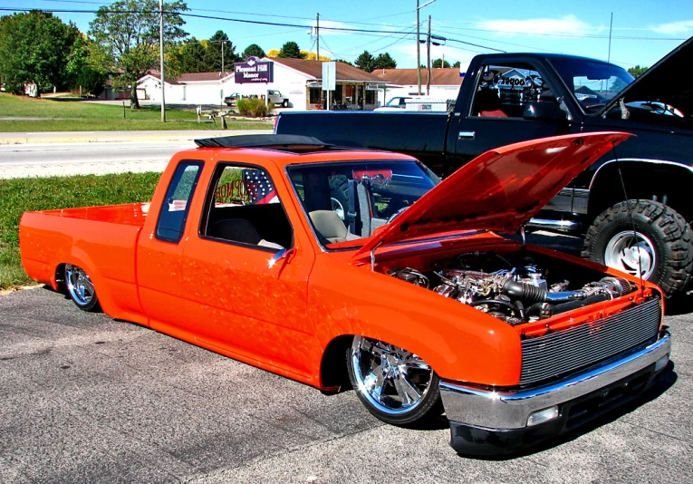 a orange truck parked in front of another black vehicle