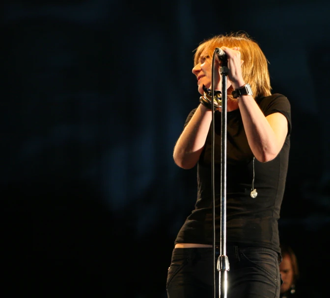 a woman holding a microphone at a concert