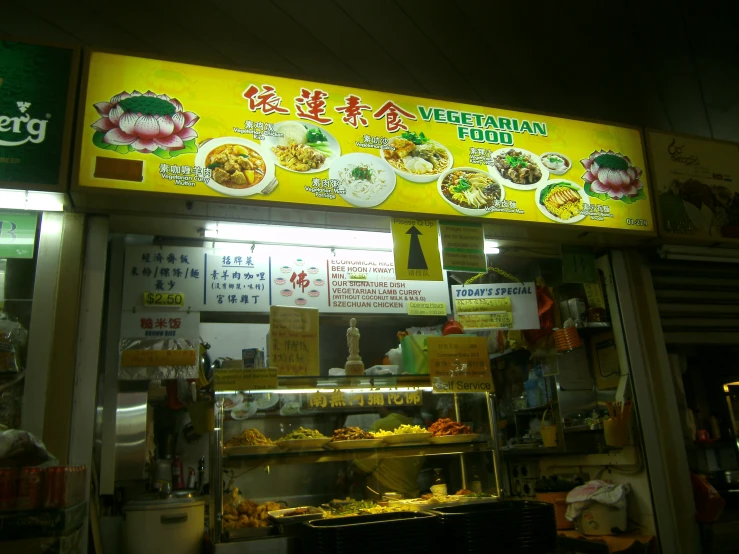 a street food stand at night with bright yellow signage