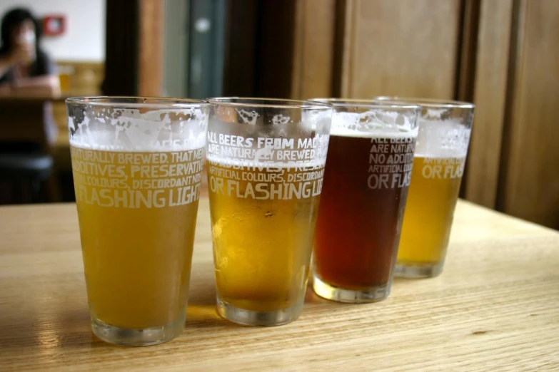 a row of glasses on top of a wooden table