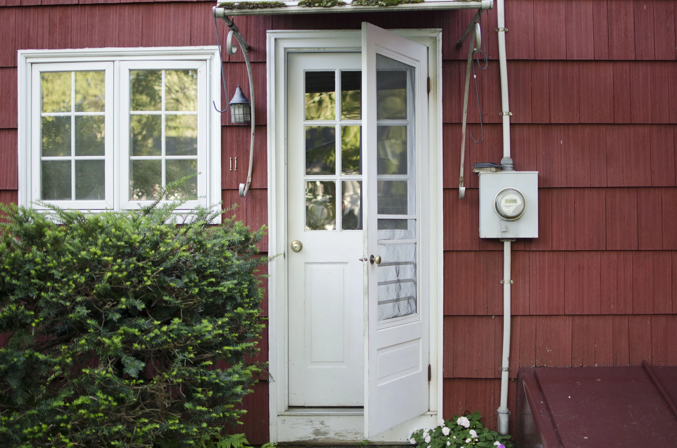 a white door on a house with red siding