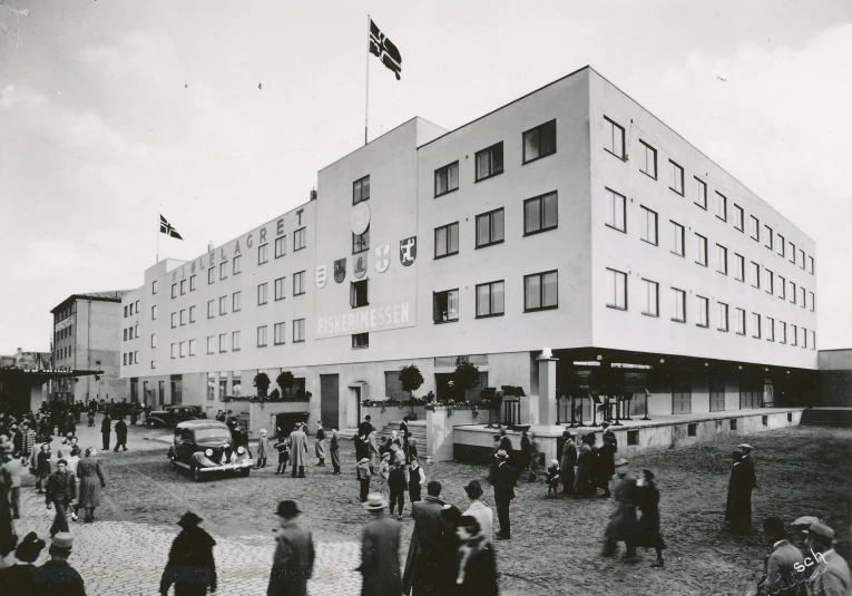 the large building has many windows and people around it