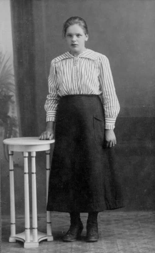 woman standing next to a table posing for a po