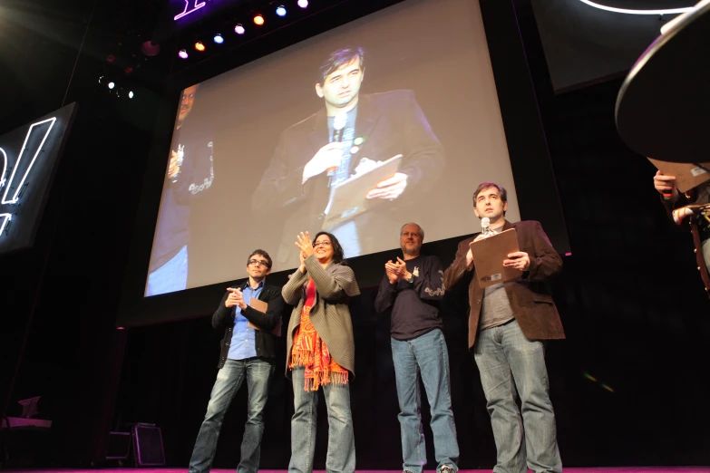 a number of people on a stage giving a presentation