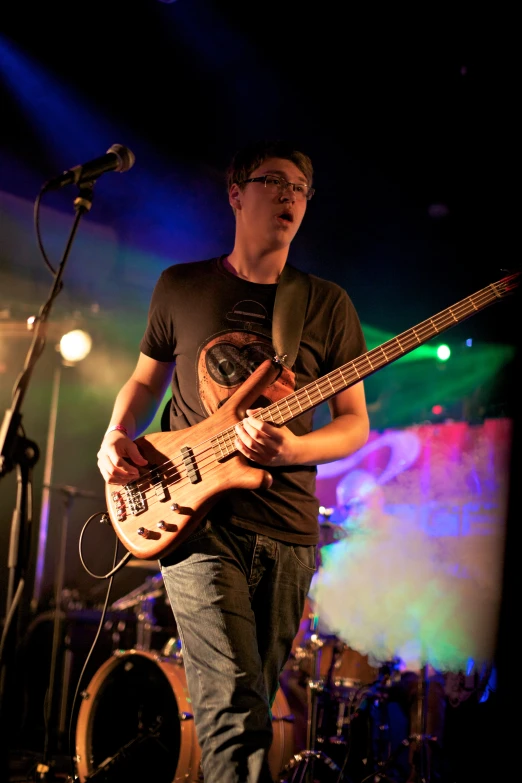 a man is playing an electric guitar while singing at a concert