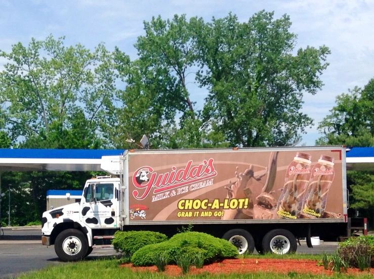 a truck parked in a parking lot next to trees