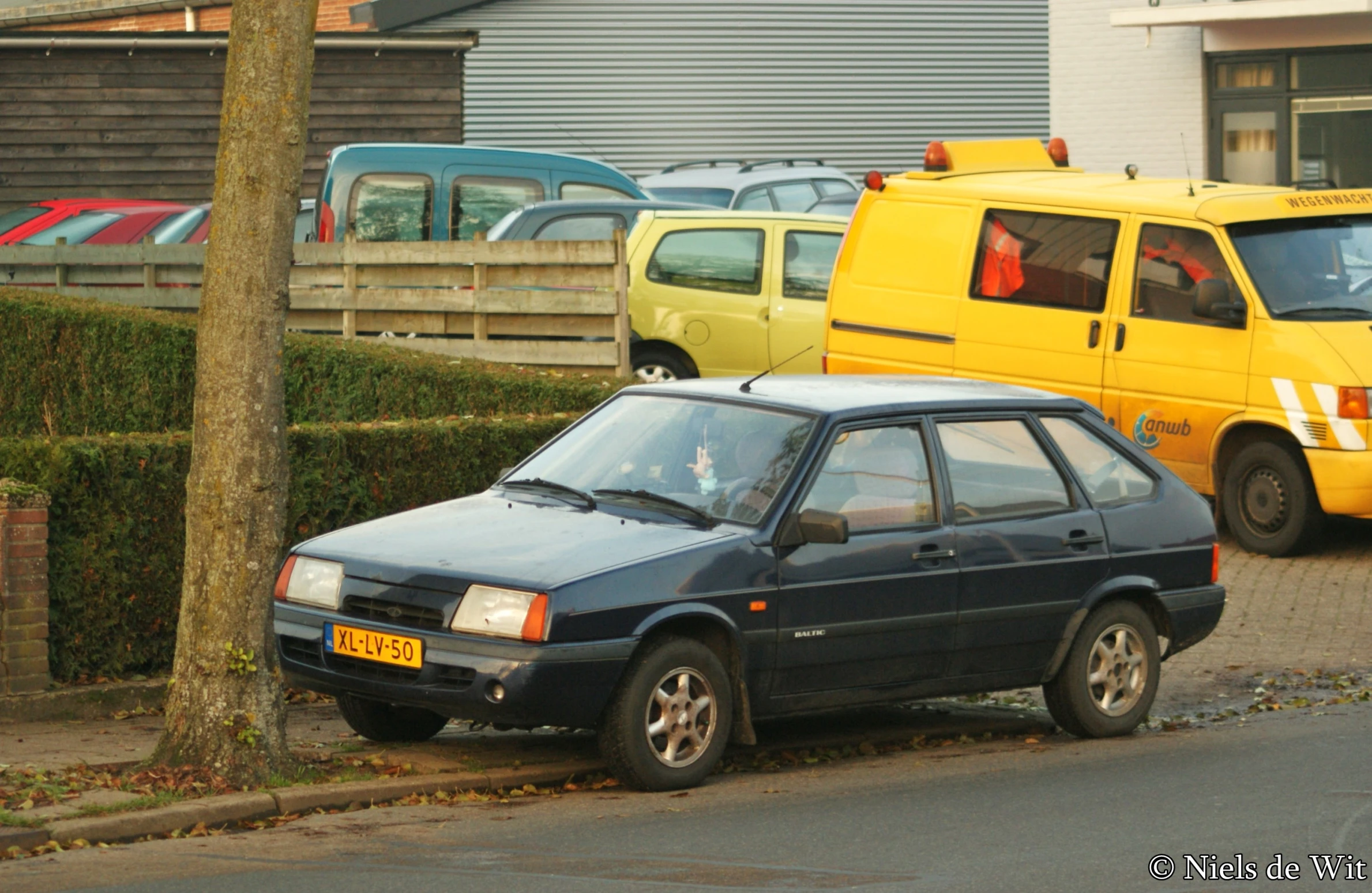 the small car is parked on the side of the street