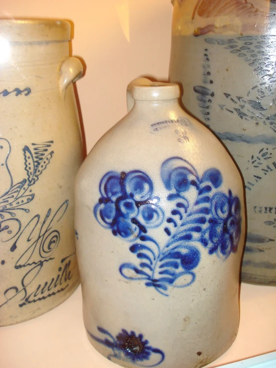 a set of three antique vases with blue flowers on the sides