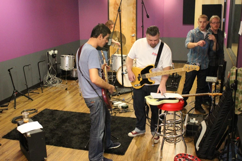 a band plays instruments in a studio with other musicians