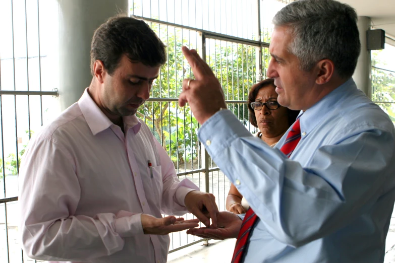 two men in business attire giving each other fingers