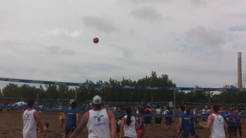 some people watching a beach volleyball game being played