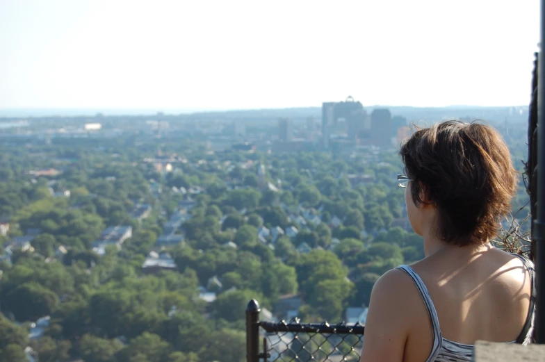 the woman with glasses is looking out over the city