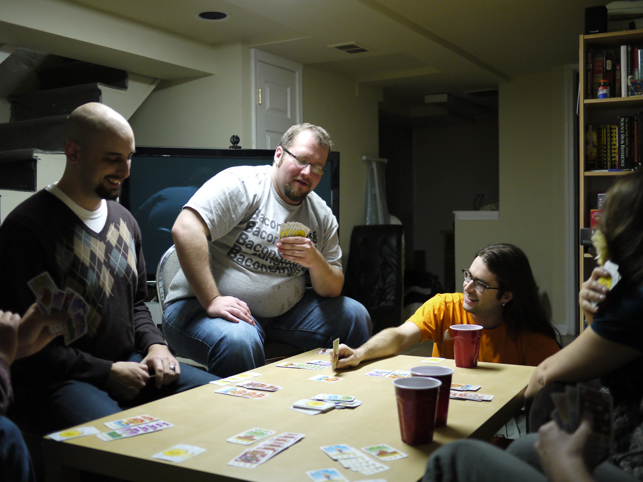 several people are sitting around a table eating and drinking