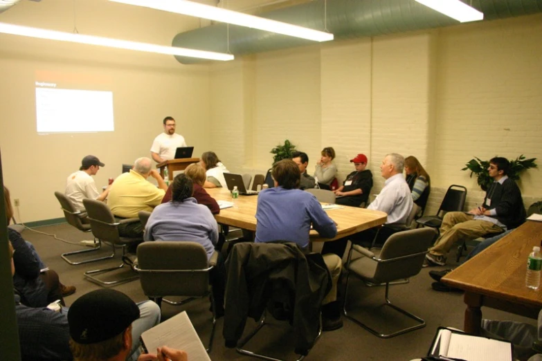 there are many people at a conference that are sitting around a table