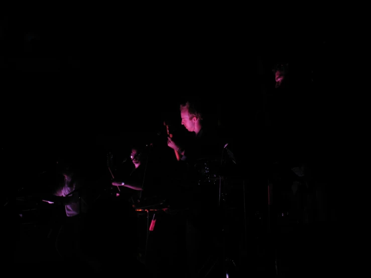 a band performs at a concert in the dark