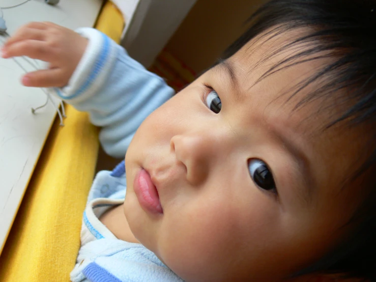 an asian baby has a wire in his mouth