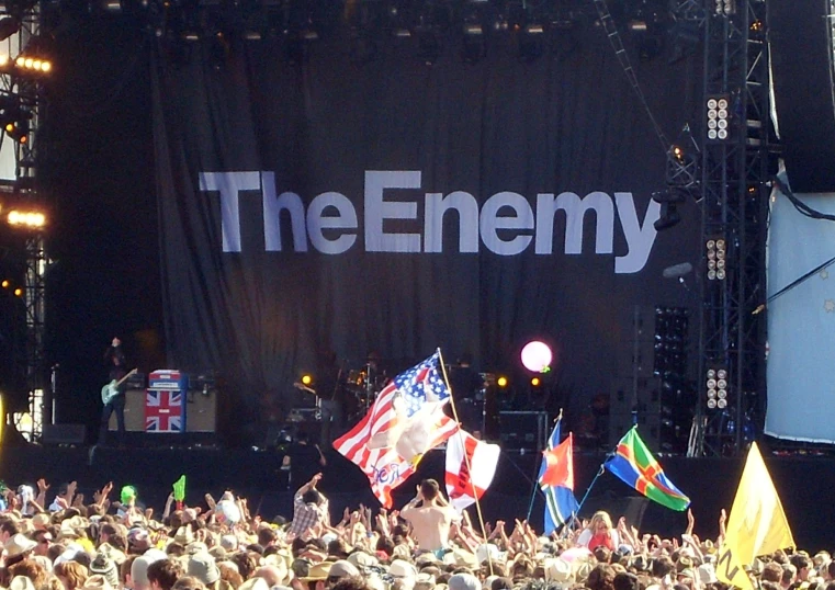 a crowd is gathered at a concert with one person holding an american flag