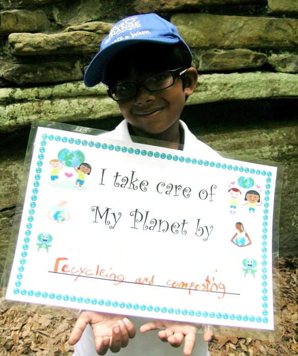 a person holding a sign that says i take care of my planet by being happy about it