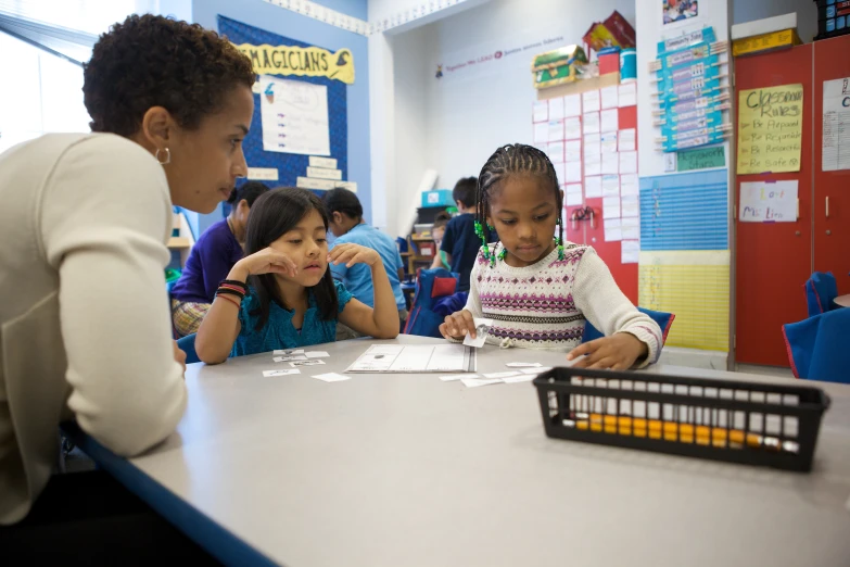 a woman teaching children in the classroom