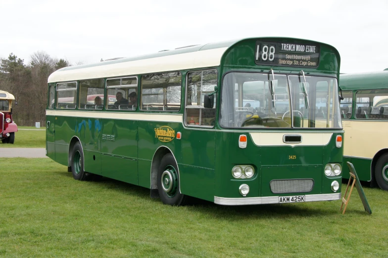 a green bus parked next to another green bus