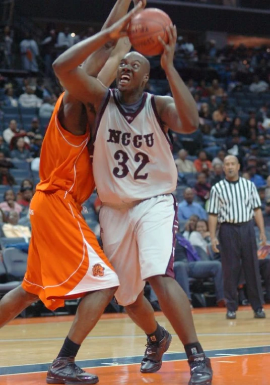 the men are playing basketball on a court