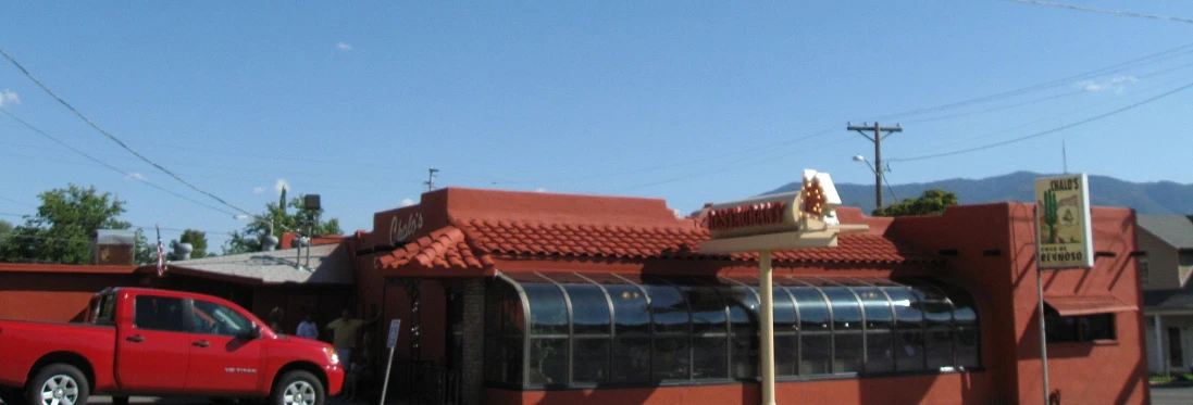 a red truck parked by a restaurant on a city street