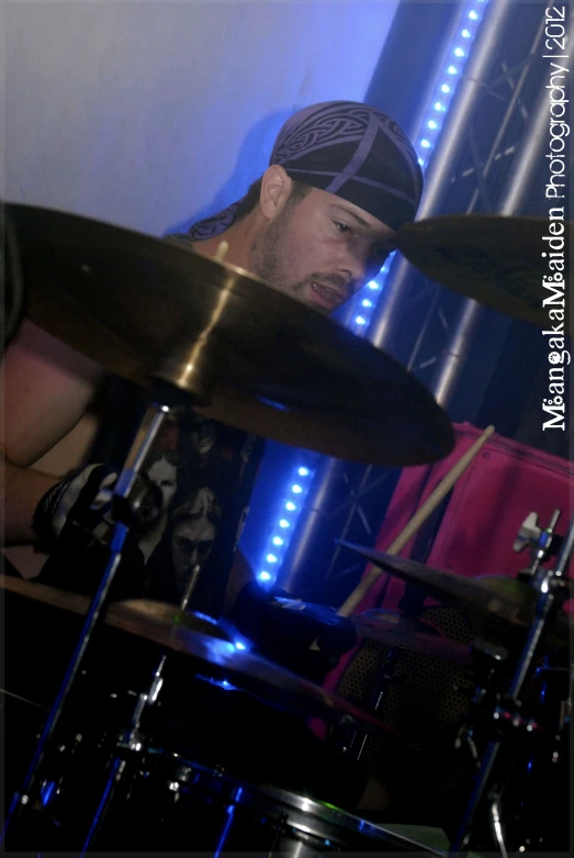 drummer playing drums in a dim lit room