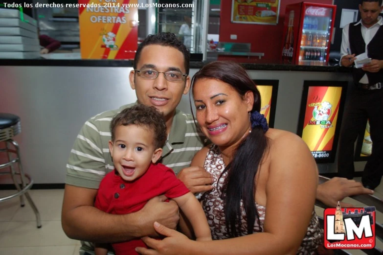 two people and a boy are smiling for the camera