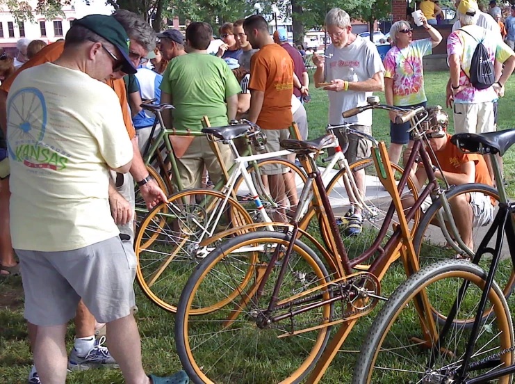 several people gathered in a field with bicycles