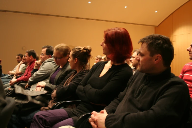 people sitting in rows looking up to the ceiling