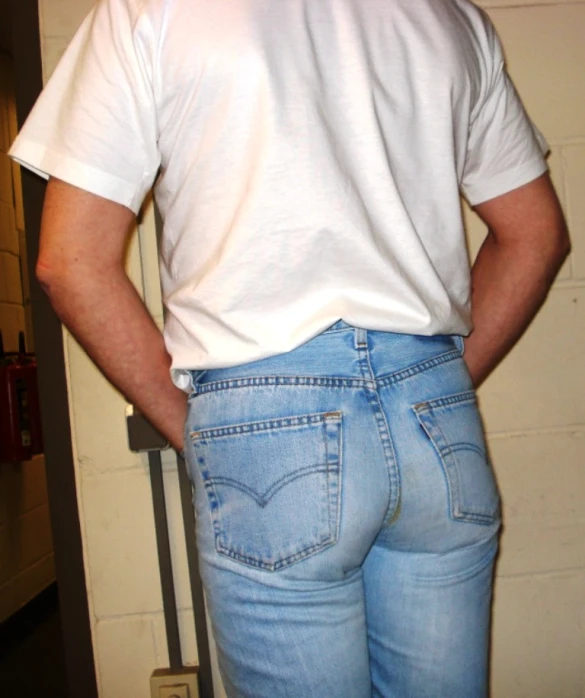 a man in a white tee shirt standing with his back to the camera