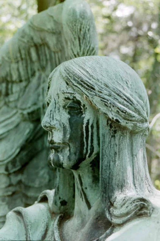 a closeup of a stone statue of a praying woman