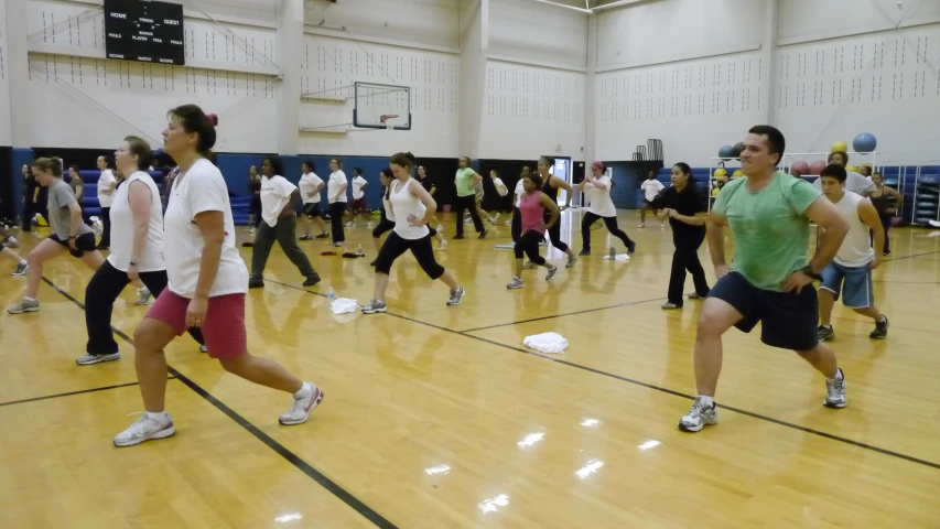 people standing on a basketball court watching other people