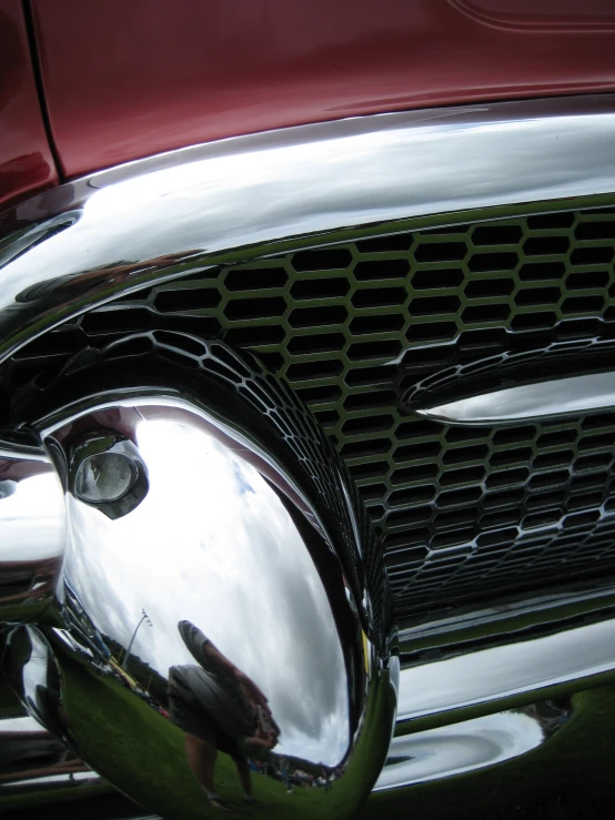 the chrome front grill of a red car