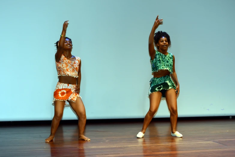 two dancers performing with a large screen behind them