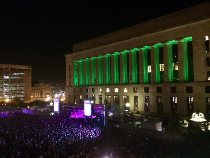 a large crowd at a concert in front of a building