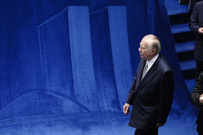 two men in suits and tie standing beside each other