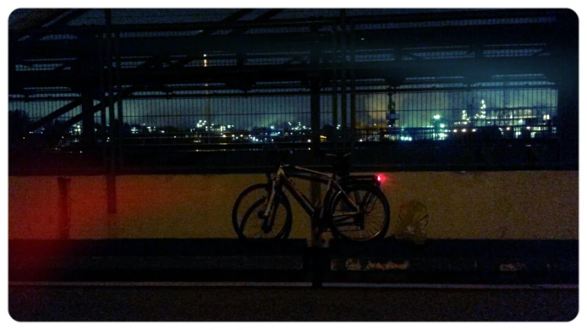 bicycle  up on metal bar at night